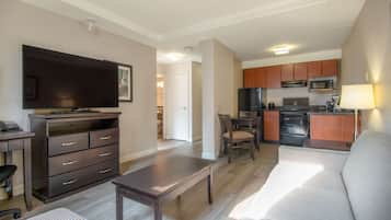 A modern apartment with a living room, dining area, and kitchen.