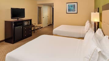 Een hotelkamer met twee bedden, een televisie, een magnetron en een bureau.