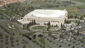 An aerial view of a large, rectangular building with a flat roof, surrounded by parking lots and greenery. - Holiday Inn Express Sacramento Airport Woodland by IHG (Woodland)