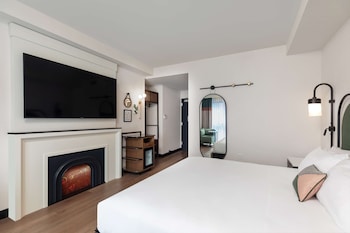 A reception area with a marble counter, bookshelves, and a decorative vase. at Pennyweight Hotel Boston, Curio Collection by Hilton