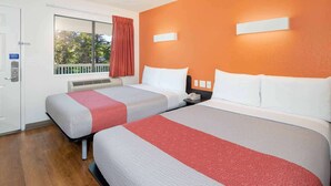 A hotel room with two beds, a window with curtains, a thermostat, and a phone on the nightstand. - Motel 6 Arcadia, CA - Los Angeles - Pasadena Area (Arcadia)