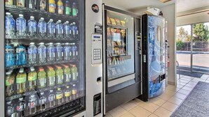 Una fila di distributori automatici di bevande con diverse opzioni.