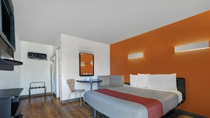 Una moderna camera d'albergo con un letto, una scrivania, una sedia e un tavolino.