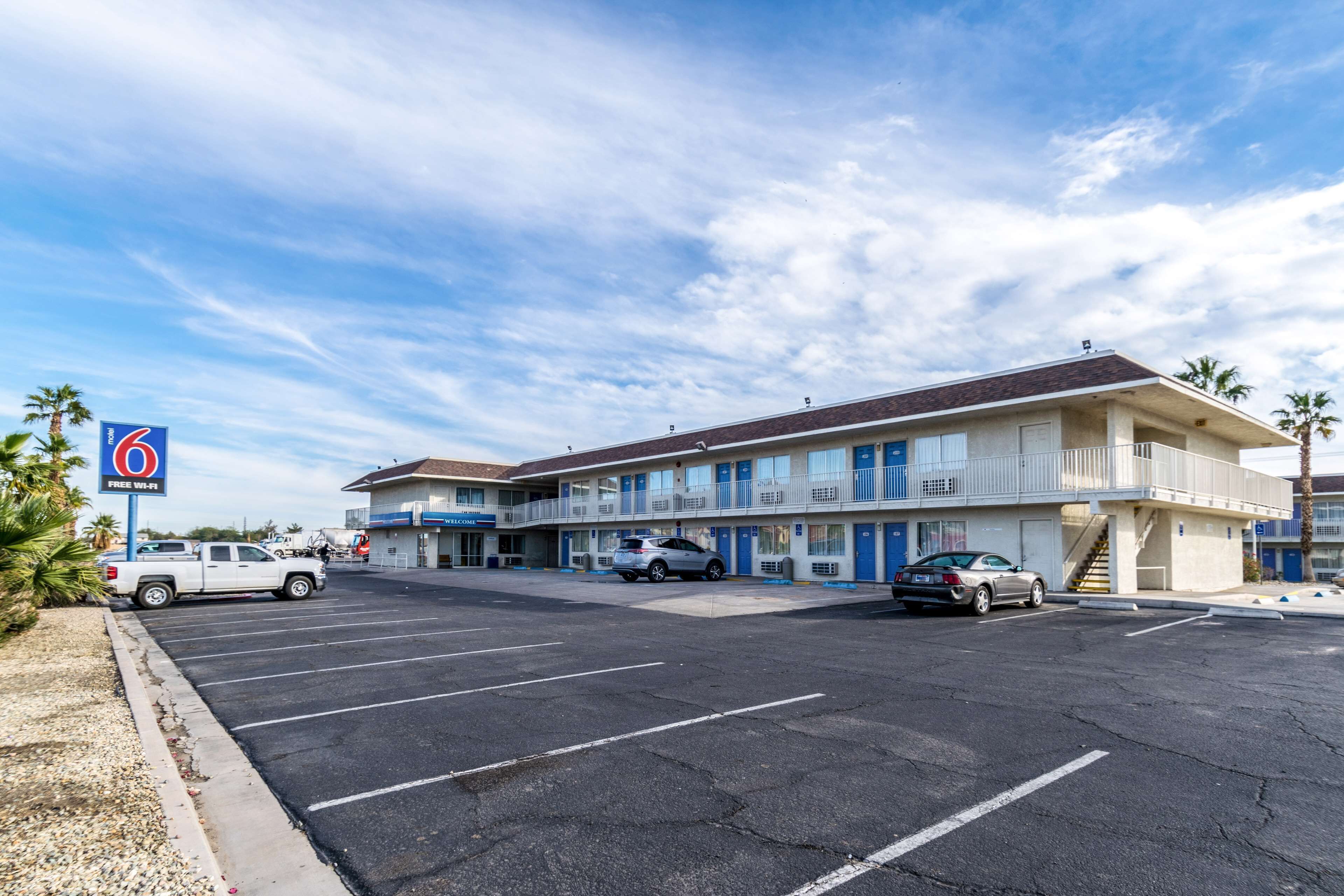 A motel with a parking lot, multiple rooms, and a sign indicating free Wi-Fi.