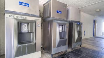 Three ice cube dispensers in a commercial setting.