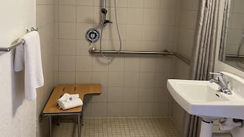 A small bathroom with a shower, a sink, and a toilet.