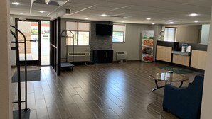 Interior moderno com cozinha, área de estar com mesa e cadeiras, e escada que dá acesso a uma área externa.