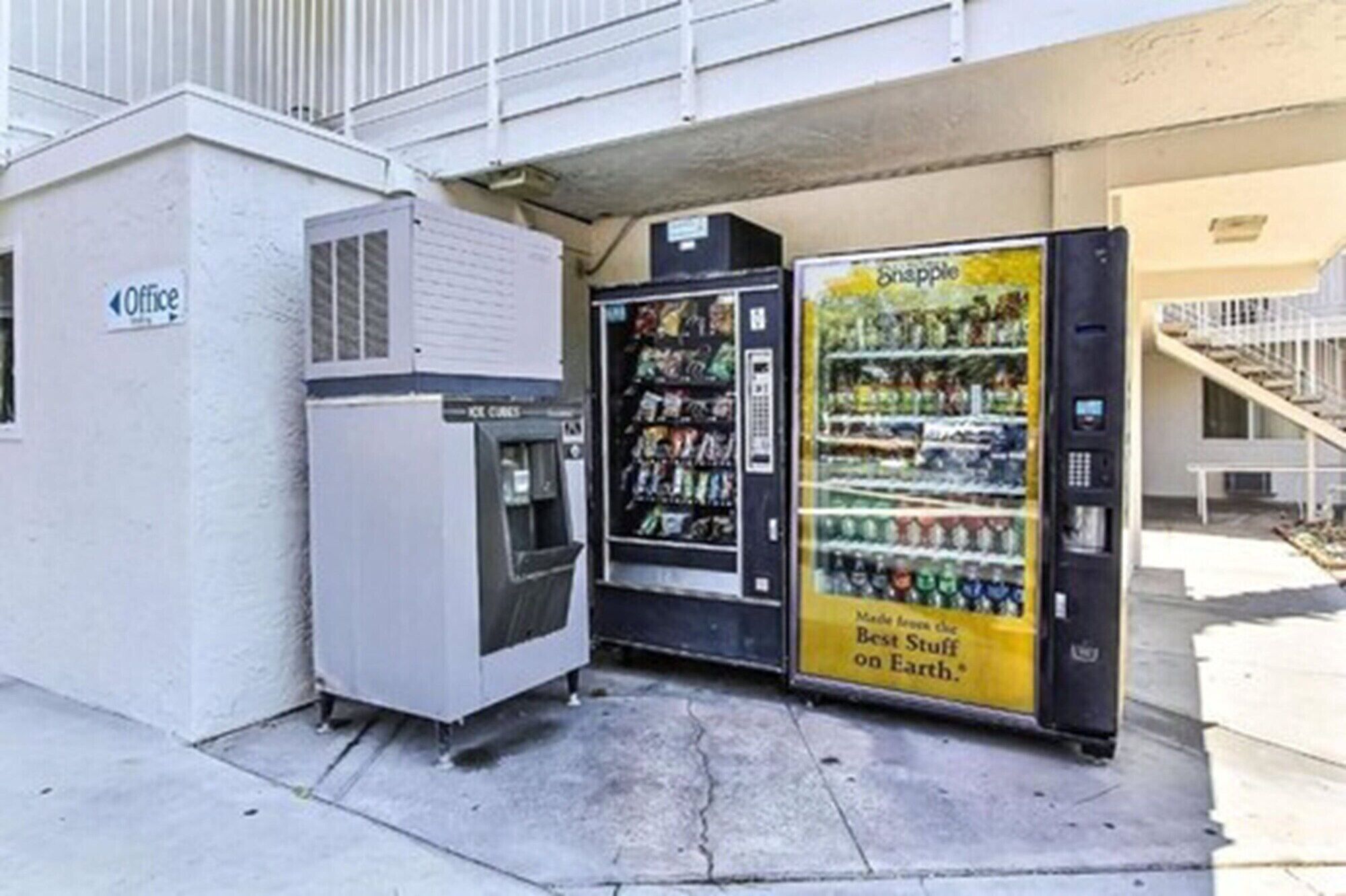 Un distributeur automatique situé sous un pont, avec une pancarte indiquant « 8happle ».
