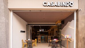 Der Eingang zu einem Restaurant namens CASABINDO, durch den ein moderner Innenraum sichtbar ist.
