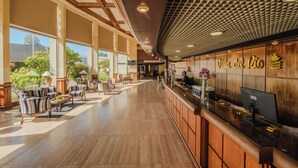 A spacious lobby with a reception desk, seating area, and large windows. - Hotel Marina Villa del Rio (Valdivia)