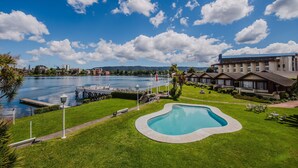 A hotel with a swimming pool, a dock, and a view of a lake. - Hotel Marina Villa del Rio (Valdivia)