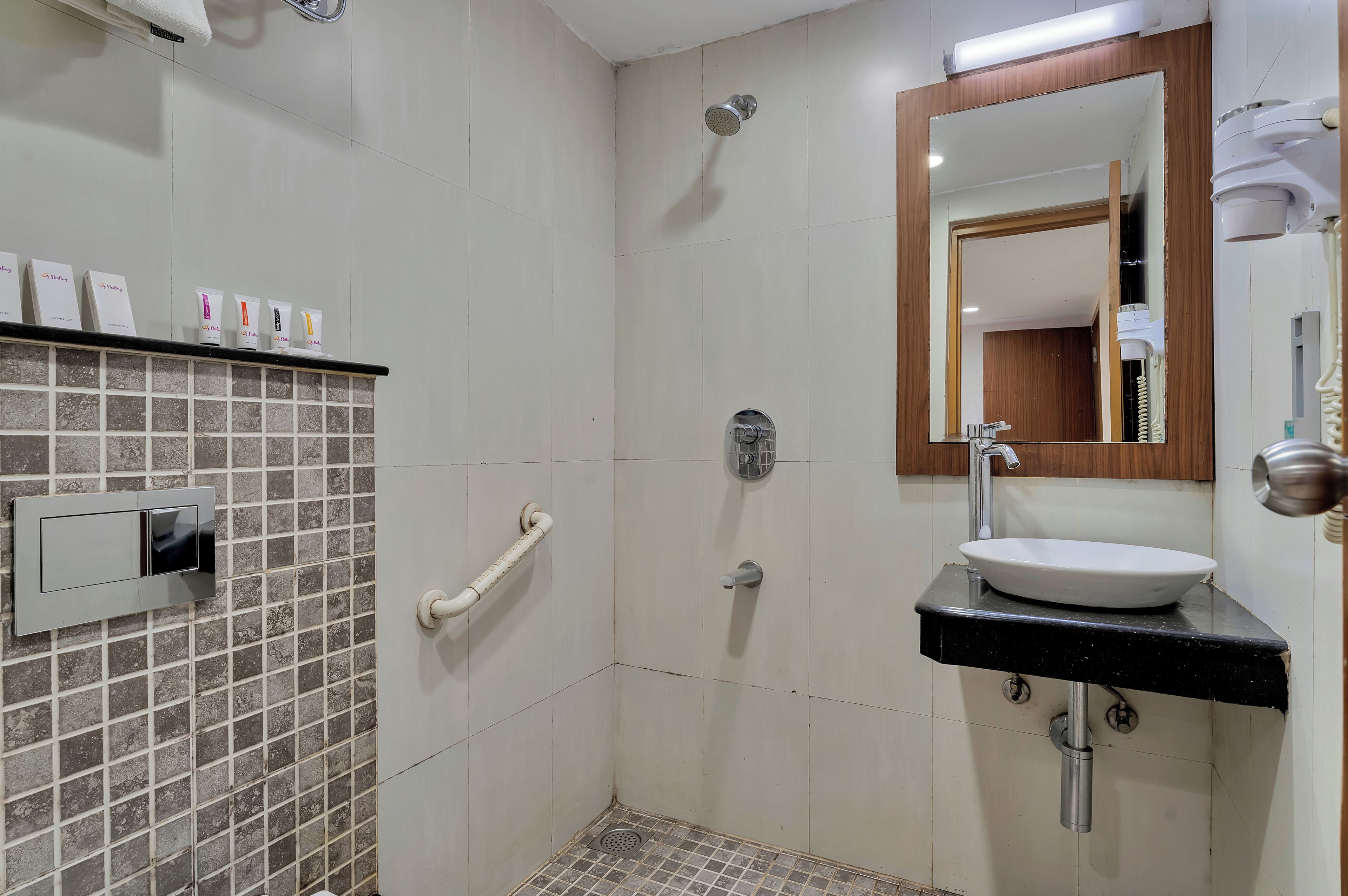 Un baño con ducha, lavabo y espejo.