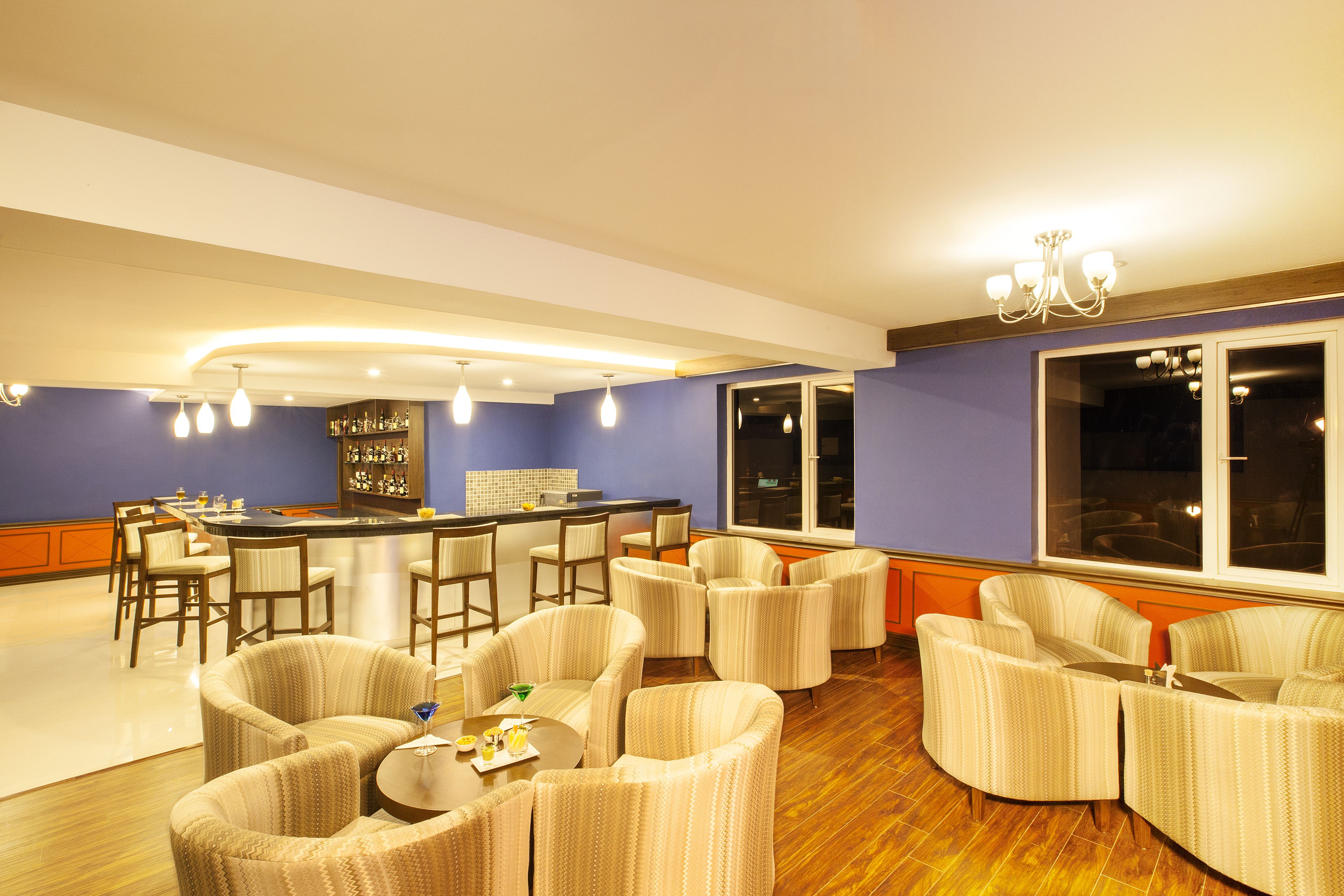 A spacious lounge area with a bar, comfortable seating, and large windows providing views.