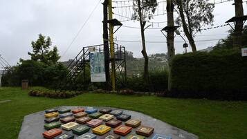 A circular arrangement of colorful boxes on a paved area, surrounded by greenery and a utility pole with a sign.