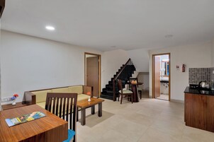 A modern living space with a dining area, a staircase, and a kitchen.