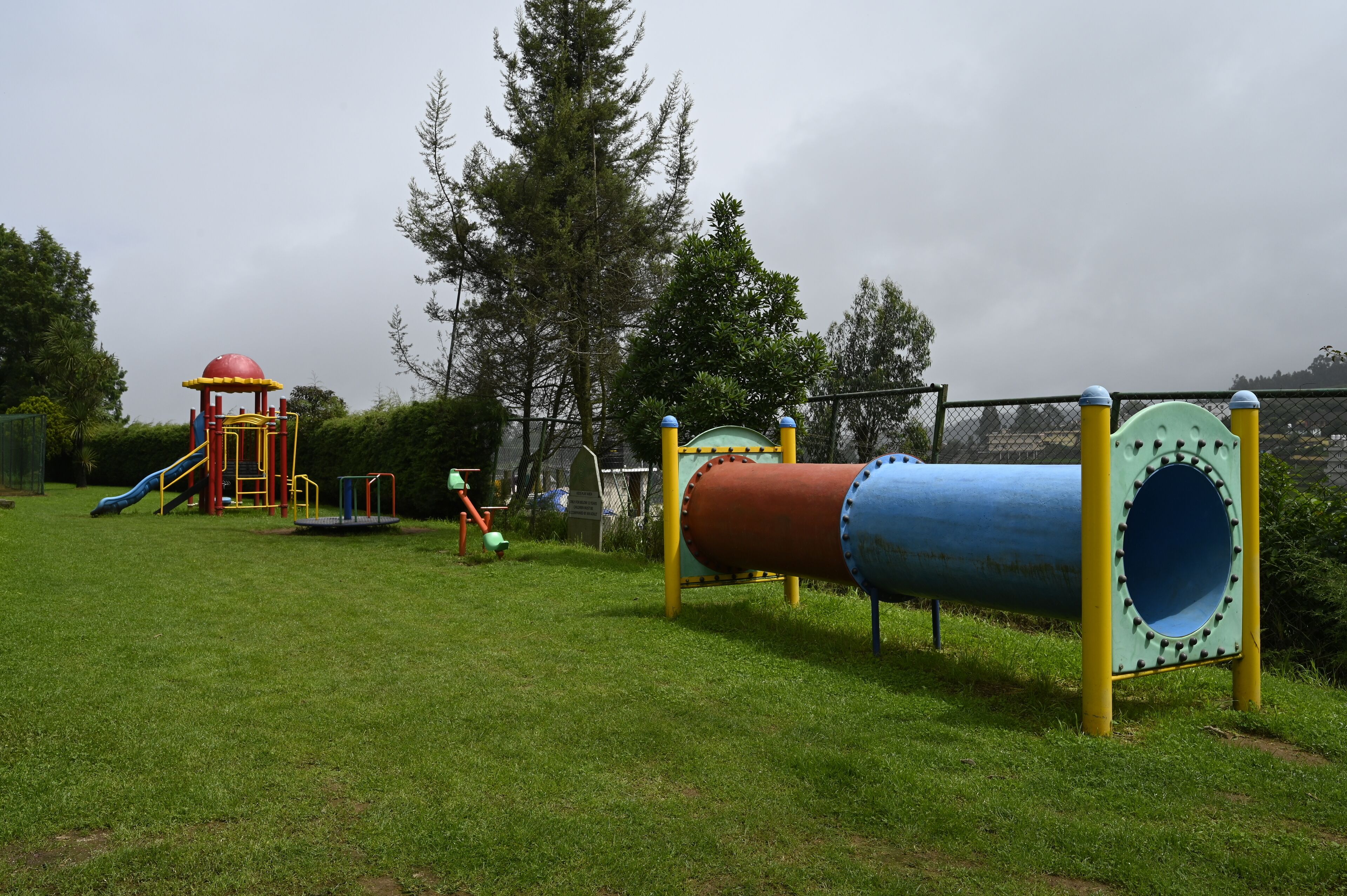 A playground with a slide, climbing structures, and a tunnel.