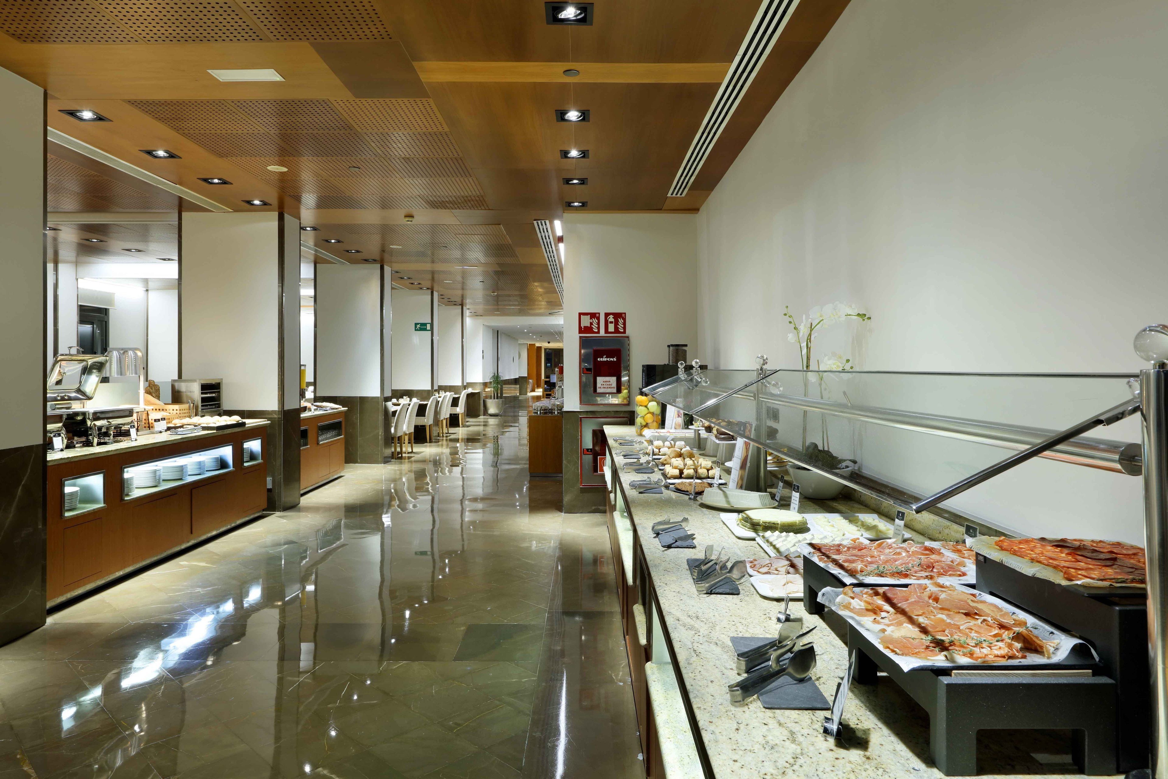 A buffet area with a variety of food options, a seating area with chairs, and a clean, polished floor.