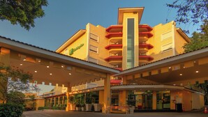 A hotel with a central tower, multiple balconies, and a covered entrance area. - Holiday Inn Cuernavaca by IHG (Cuernavaca)
