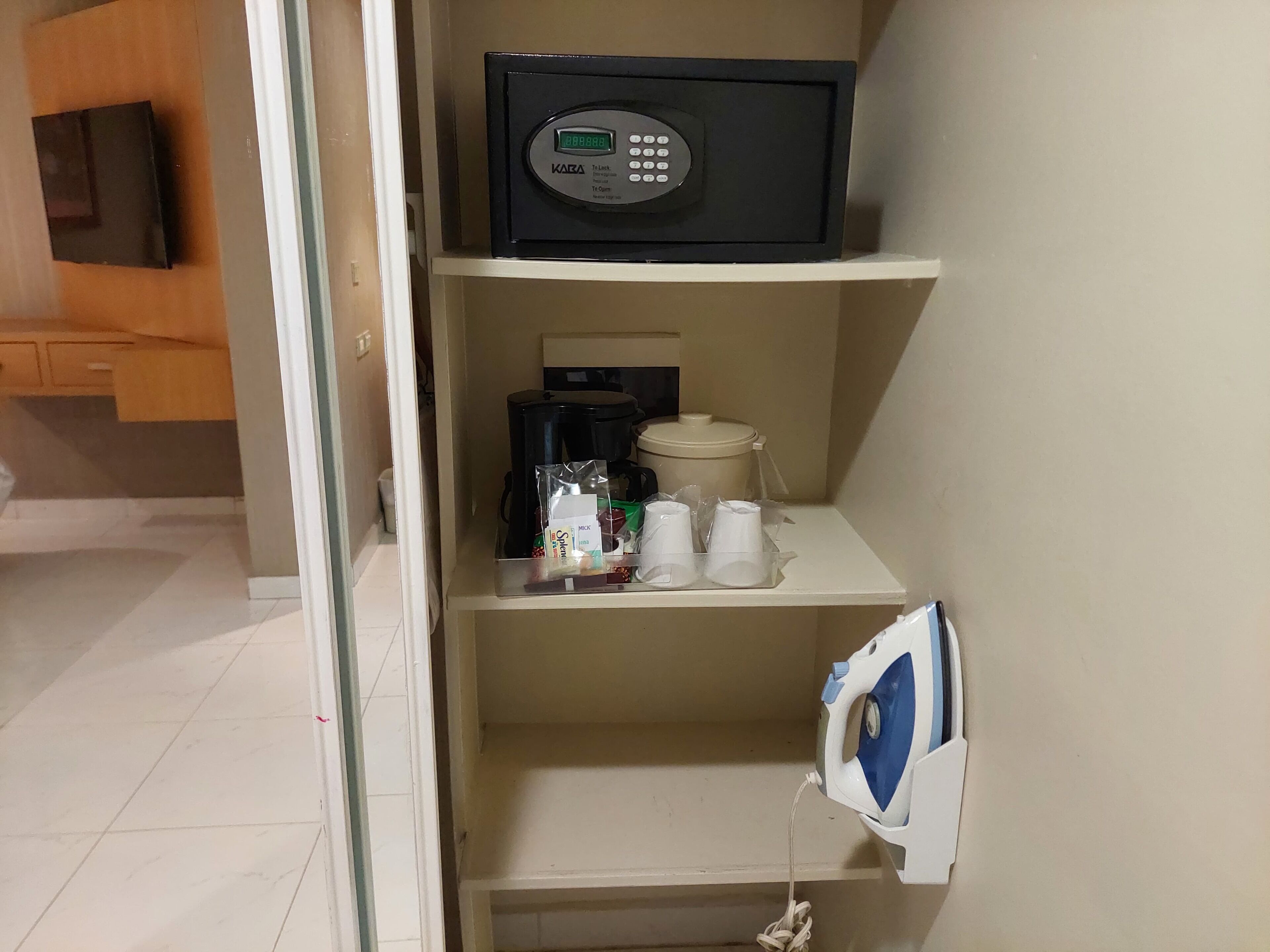 A kitchenette with a microwave, coffee maker, and storage containers.