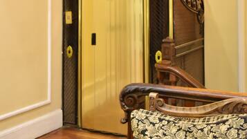 An elevator with a decorative metal grille and a wall-mounted light fixture.