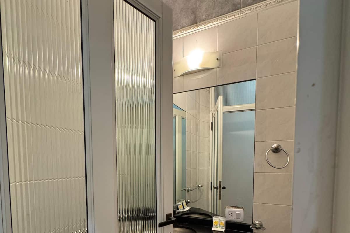 A bathroom with a toilet, sink, and mirror.