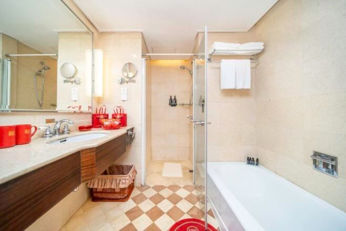 Un baño moderno con un espejo grande, dos lavabos, una ducha y una bañera.