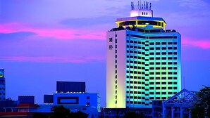 A high-rise building with a prominent tower and a large illuminated sign. - Zhongshan International Hotel (Zhongshan)