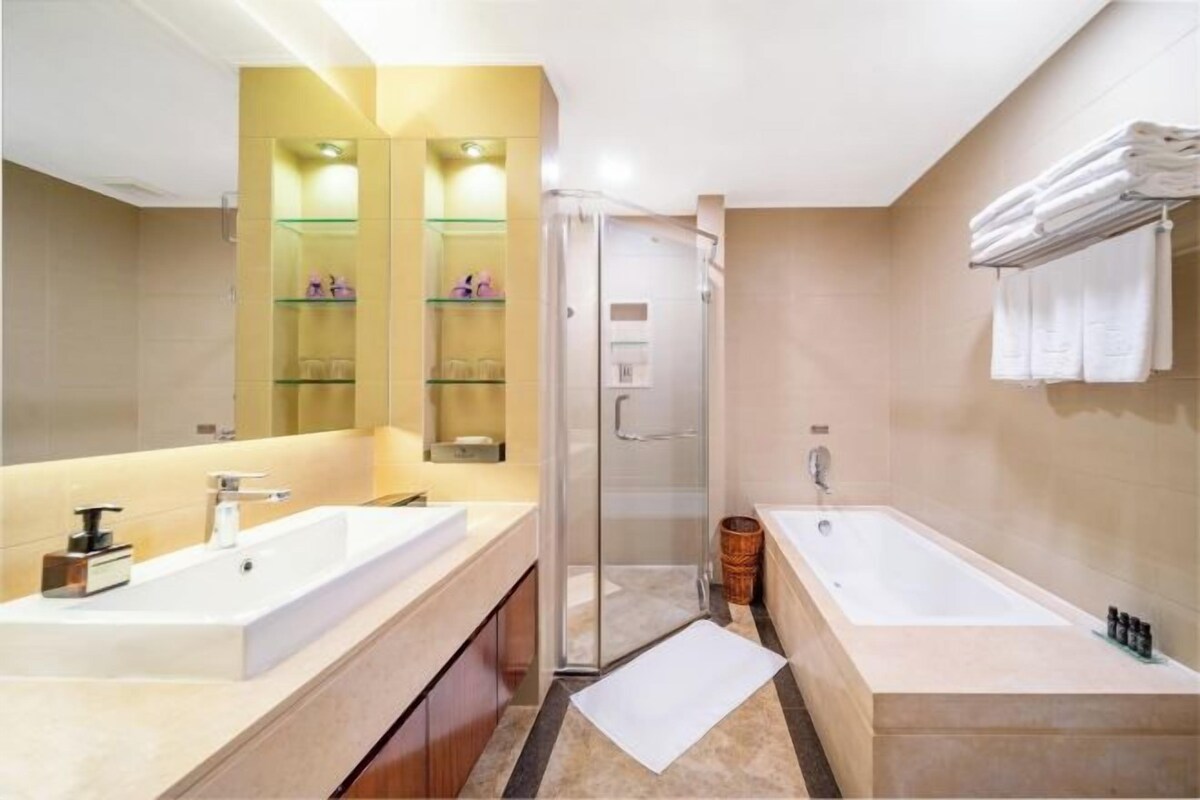 Un baño moderno con un espejo grande, dos lavabos, ducha y bañera.