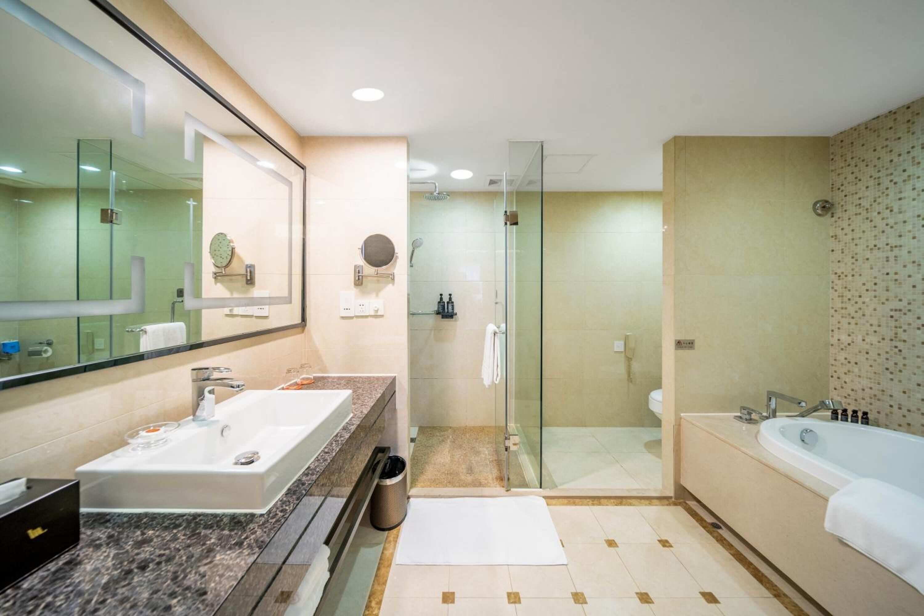 Un baño moderno con un espejo grande, un lavamanos, una ducha y una bañera.