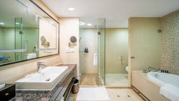 Un baño moderno con un espejo grande, un lavamanos, una ducha y una bañera.