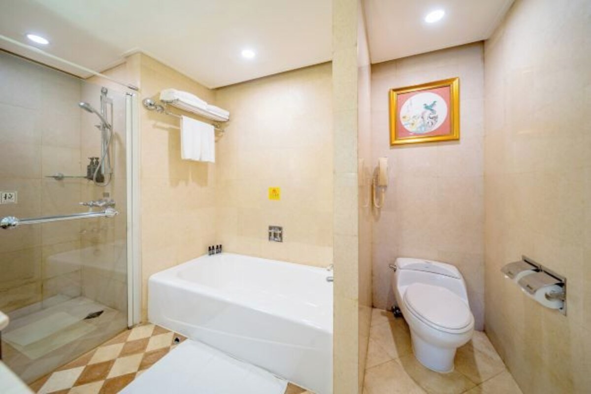 Un baño con bañera, inodoro y cabina de ducha de vidrio.