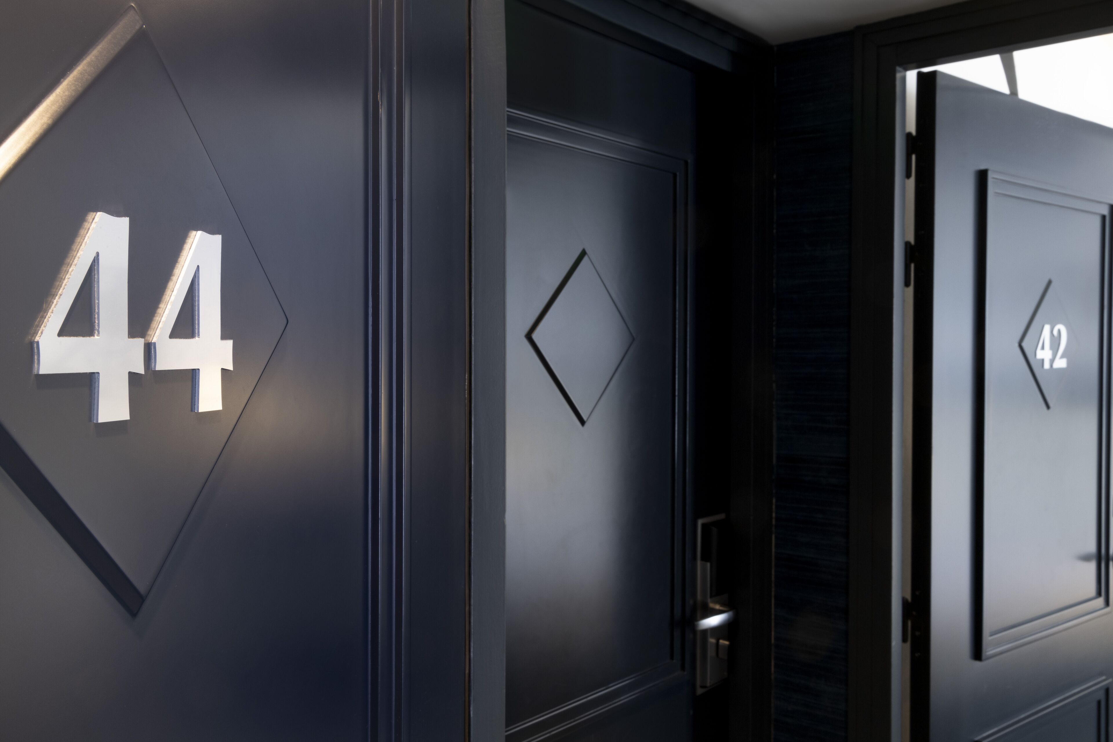 Facciata di un edificio moderno con grandi numeri '44' e '42' che indicano i numeri delle camere.