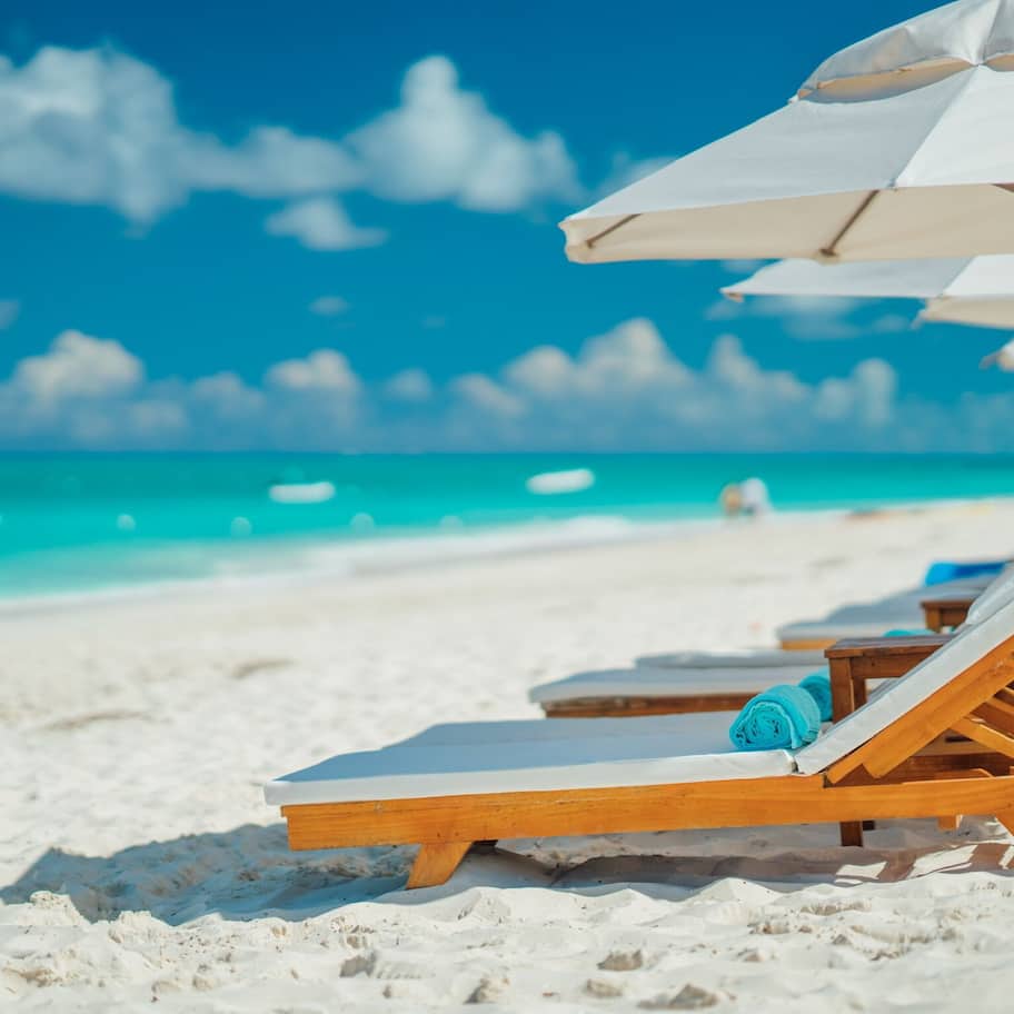 On the beach, white sand, sun loungers, beach umbrellas