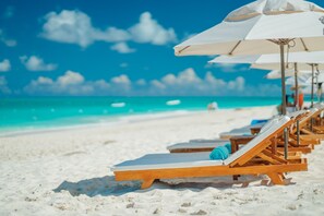 On the beach, white sand, sun loungers, beach umbrellas