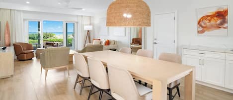Un comedor moderno con una mesa larga, sillas y una lámpara colgante.