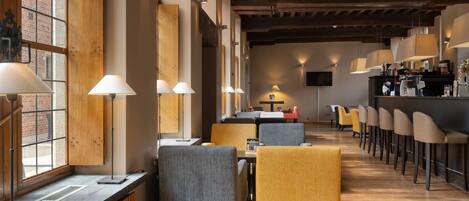 A modern restaurant with wooden beams, tables, and chairs.