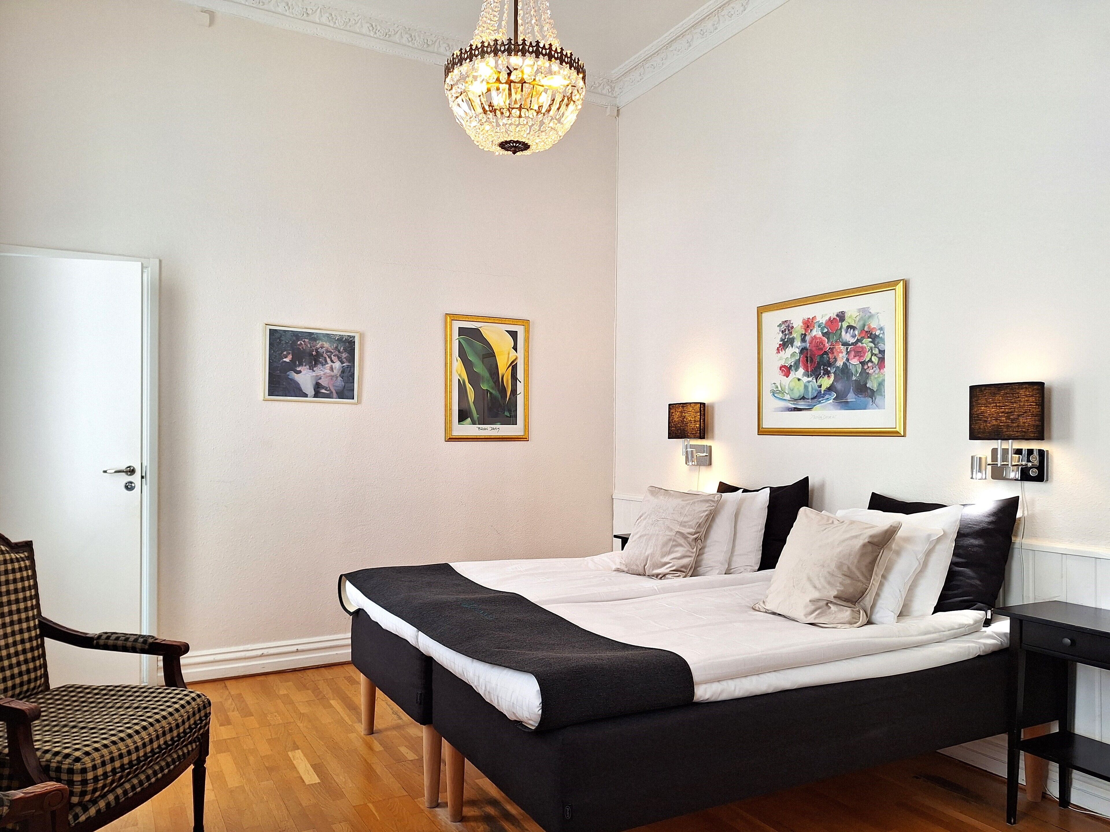 Une chambre à coucher avec un lit, une chaise et un lustre.