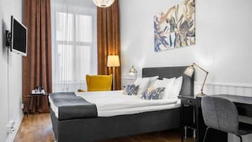 Une chambre d’hôtel moderne, équipée d’un lit, d’un bureau et d’une chaise.