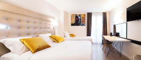 A hotel room with a large bed, a desk, a chair, a flat-screen TV, and a painting on the wall.