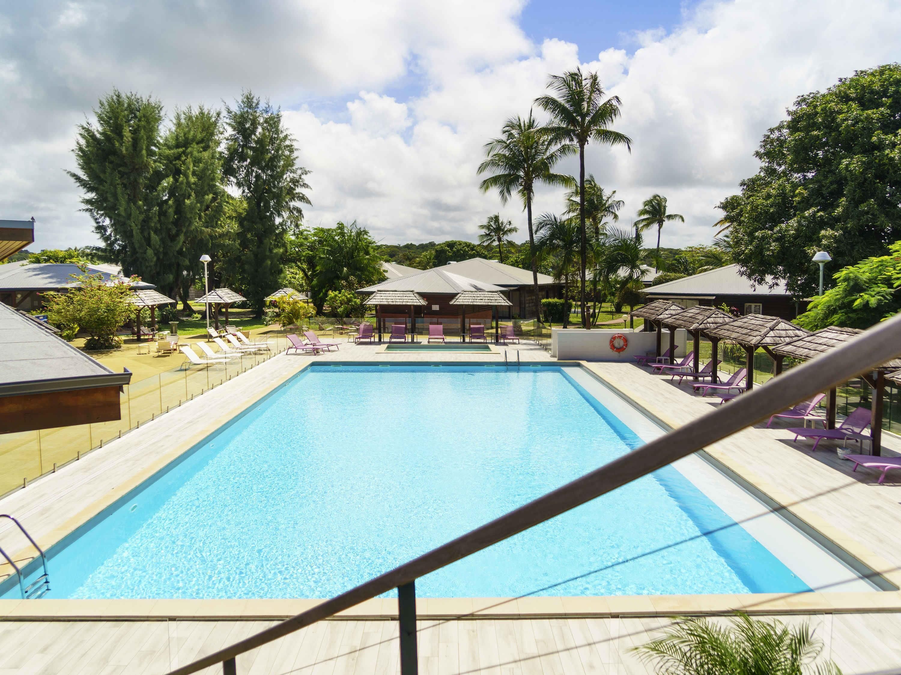 Una piscina al aire libre, sillones reclinables de piscina