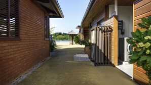 Un camino que lleva a un edificio de fachada de ladrillo y una terraza de madera.