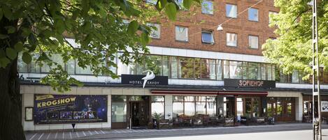 A hotel with a modern facade, a visible restaurant named 'Sofiehof' across the street, and a 'KROGSHOW' advertisement on the building.