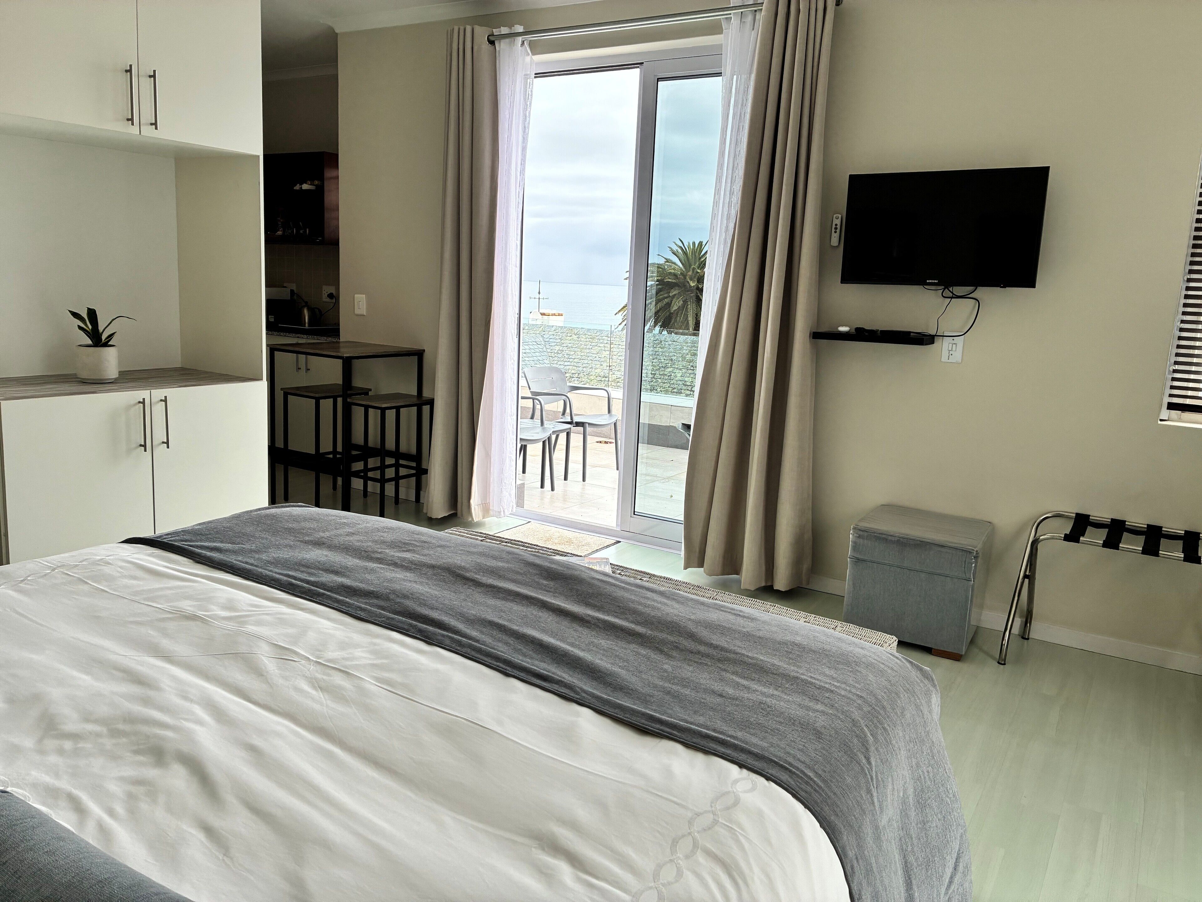 Una habitación de hotel con cama, televisión, escritorio y vistas al exterior.