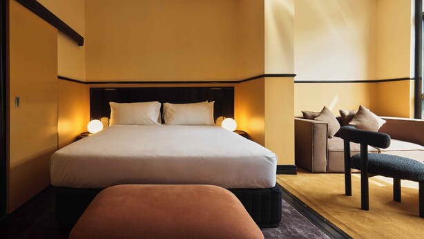 Une chambre d’hôtel avec un grand lit, un canapé et un fauteuil.