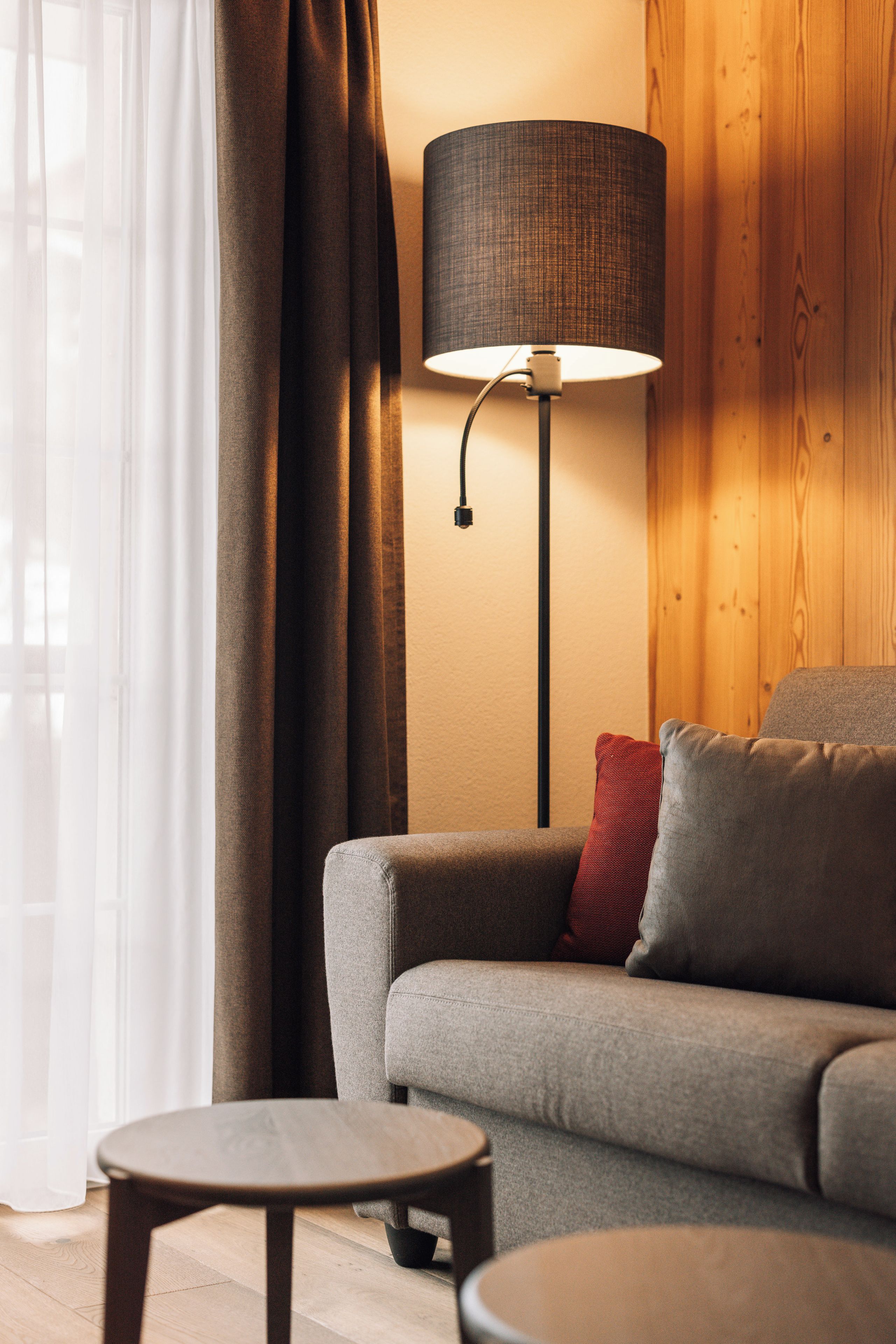 A modern living room with a sofa, a round coffee table, and a floor lamp.
