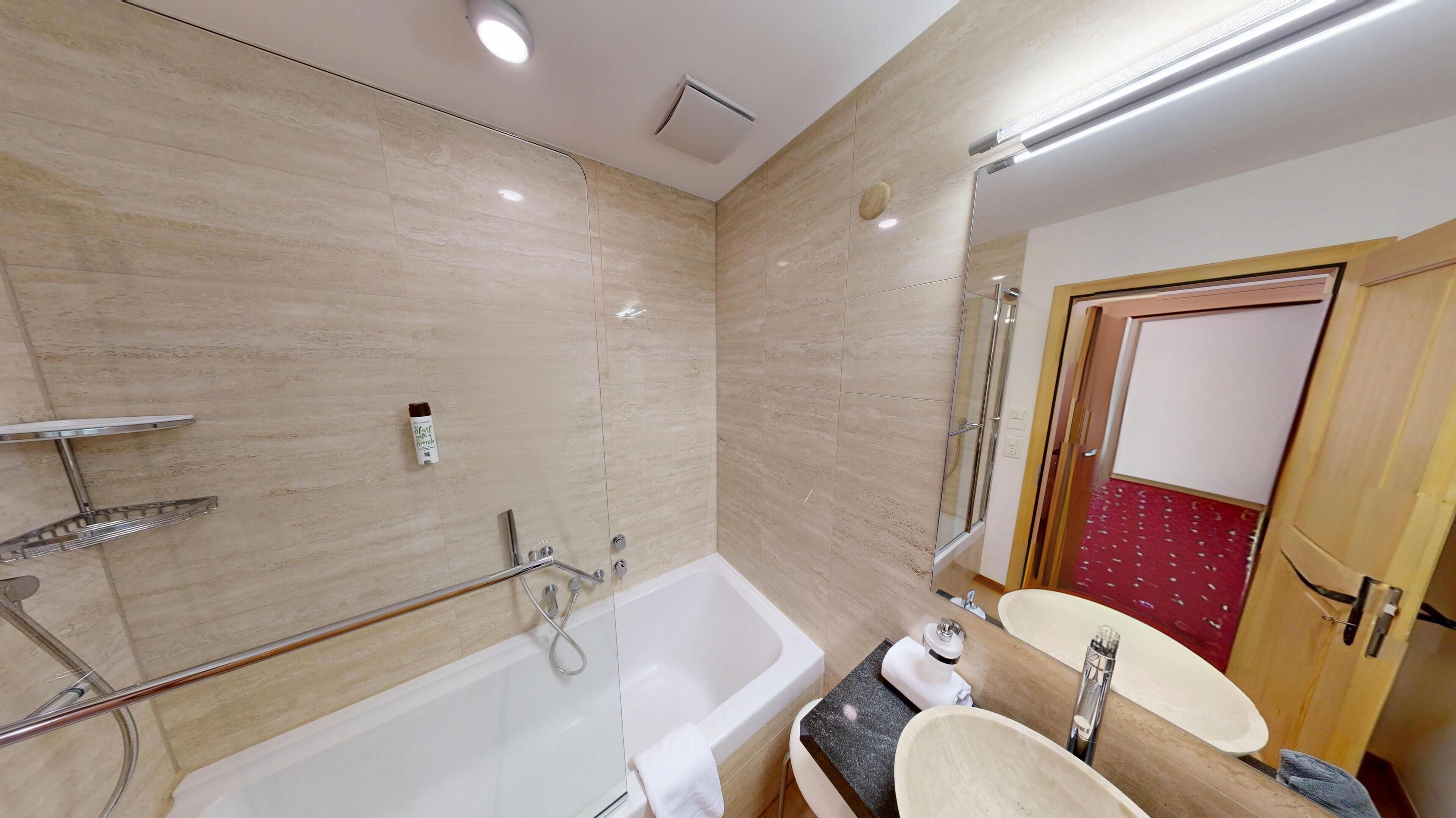 A modern bathroom with a bathtub, a sink, and a shower.