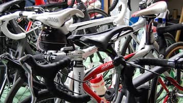 Varias bicicletas estacionadas juntas, probablemente en un área de almacenamiento o un servicio de alquiler de bicicletas.