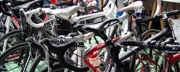 Varias bicicletas estacionadas juntas, probablemente en un área de almacenamiento o un servicio de alquiler de bicicletas.