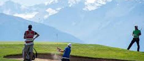 Un campo de golf con montañas al fondo.