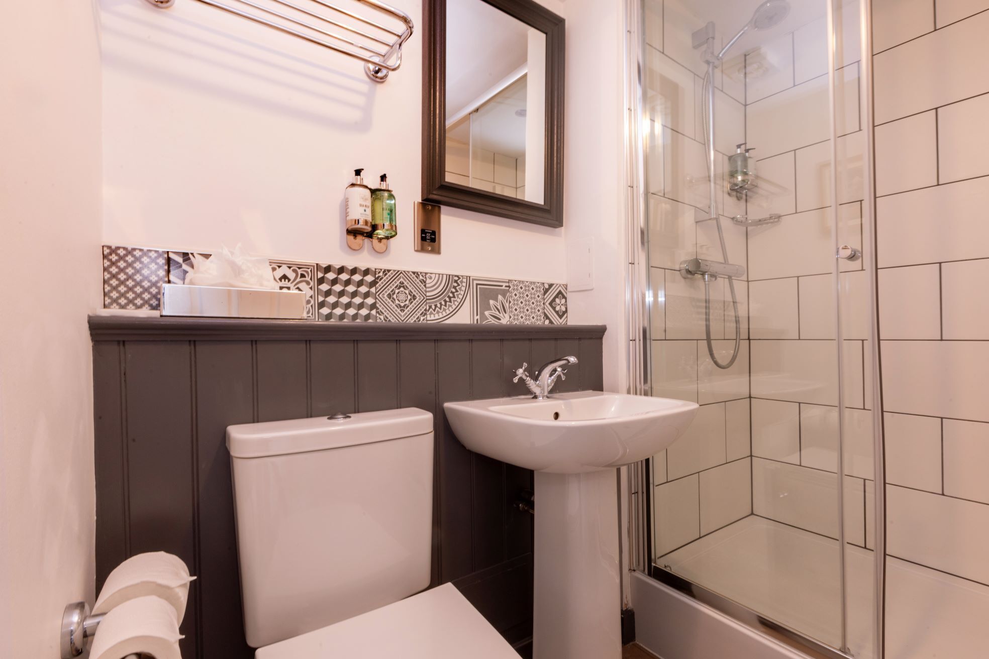 A bathroom with a toilet, sink, and shower.